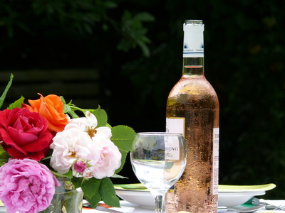 bouteille de vin rosé, verre et bouquet de roses