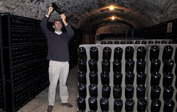 Pierre examine le dépôt laissé par la seconde fermentation dans la bouteille. Pierre examine le dépôt laissé par la seconde fermentation dans la bouteille.