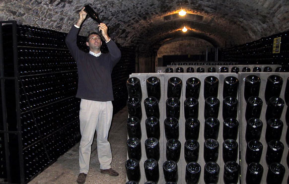 Pierre examine le dépôt laissé par la seconde fermentation dans la bouteille.