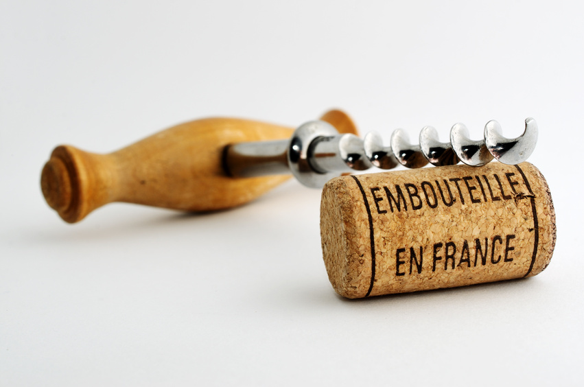 vintage corkscrew and wine cork with inscription embouteille en